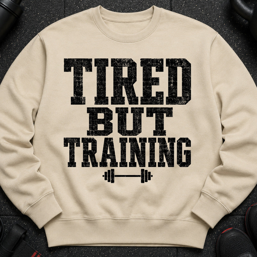 Light beige sweatshirt with "TIRED BUT TRAINING" text and barbell graphic.