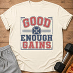 Cream t-shirt with "GOOD ENOUGH GAINS" graphic and weight plate icon.