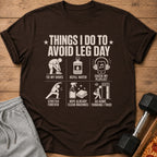 T-shirt with text "Things I do to avoid leg day" and humorous illustrations.