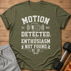 Green t-shirt with "Motion Detected. Enthusiasm Not Found." text and graphics.