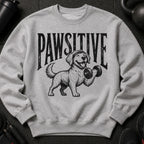 Gray sweatshirt with black graphic of dog lifting dumbbell and text "PAWSITIVE".
