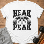 White t-shirt with black distressed graphic of a pelican lifting a barbell, text BEAK PEAK.