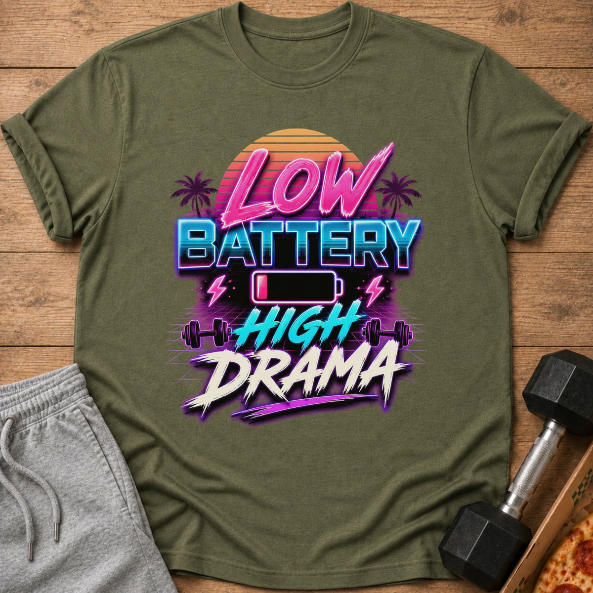Olive green t-shirt with text "Low Battery High Drama" and gym graphics.