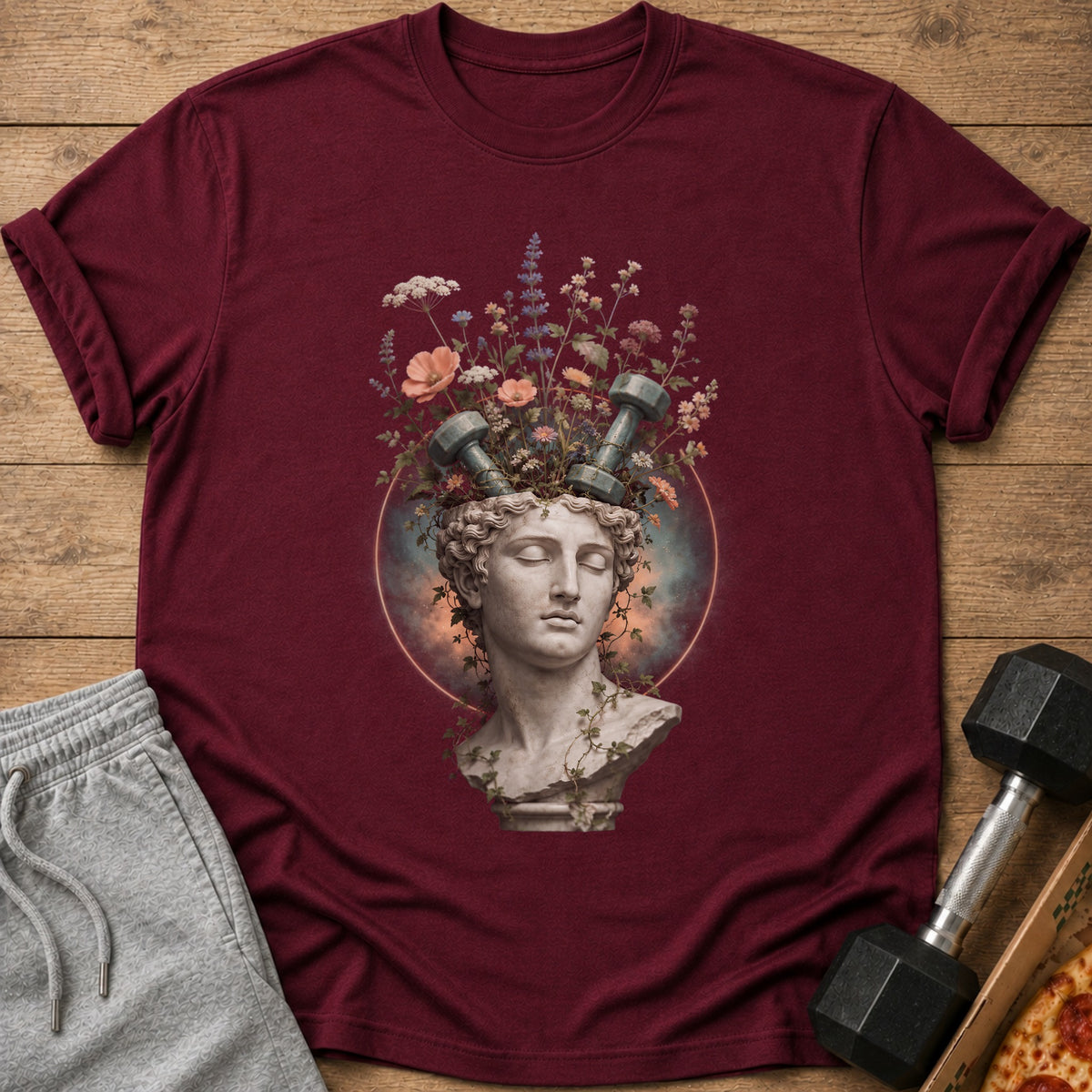 Burgundy t-shirt featuring a marble bust with flowers and dumbbells sprouting from its head.