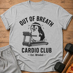 Grey t-shirt with a cartoon penguin on a treadmill and text "OUT OF BREATH CARDIO CLUB - Est. Winded -".