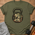 Olive green t-shirt with a graphic of a gym scene inside a kettlebell.