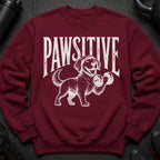 Maroon sweatshirt with white distressed graphic of a dog lifting a dumbbell and the text "PAWSITIVE".