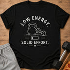 Black t-shirt with white text and graphics of gym equipment and a low battery symbol.
