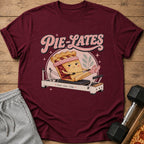 Maroon t-shirt with "Pie-Lates" text and a pie character on a reformer.