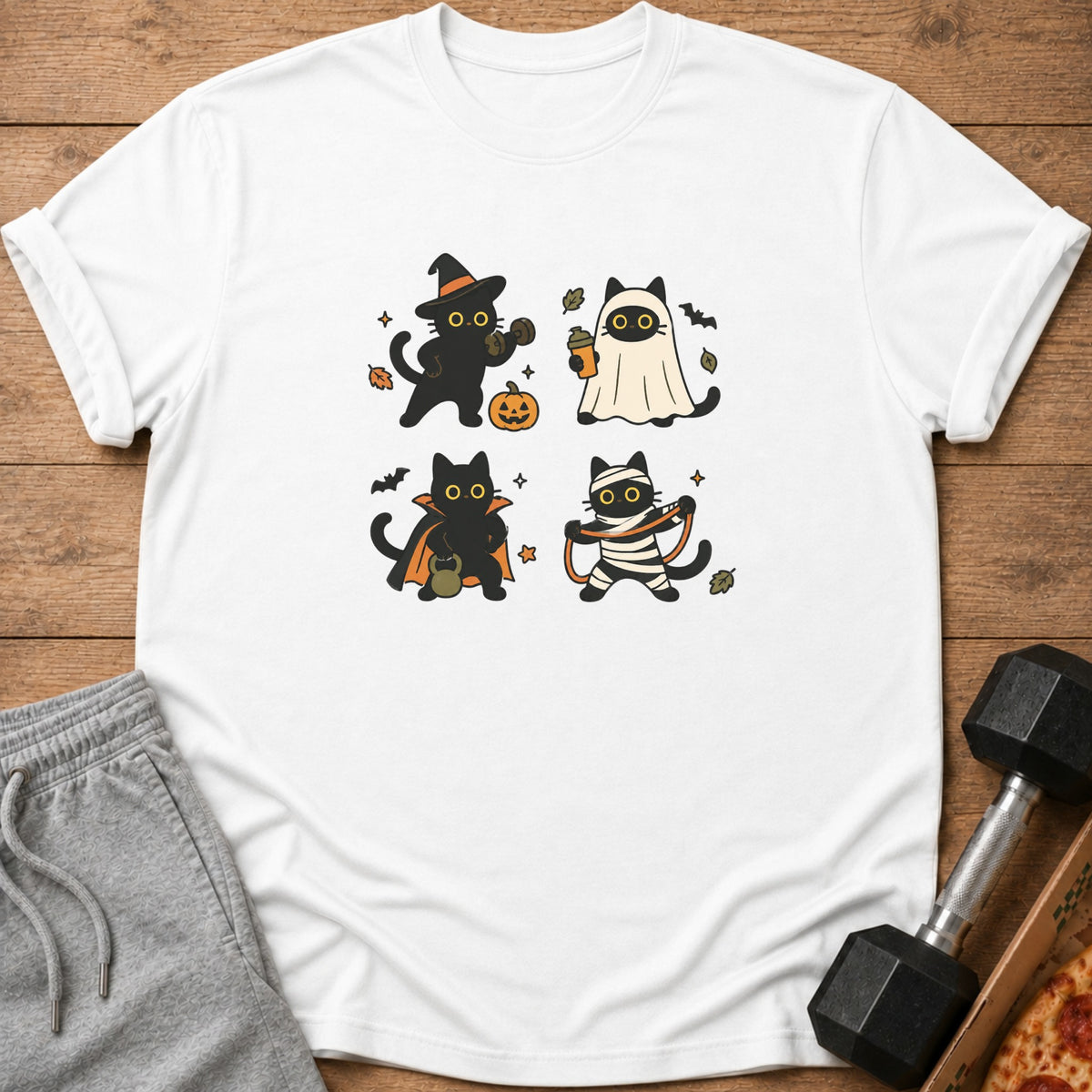 White t-shirt with four cartoon black cats dressed in Halloween costumes.