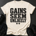 Cream t-shirt with black distressed text "GAINS SEEM UNLIKELY" and a dumbbell icon.