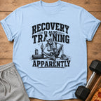 Light blue t-shirt with skeleton graphic and "RECOVERY IS ALSO TRAINING APPARENTLY" text.