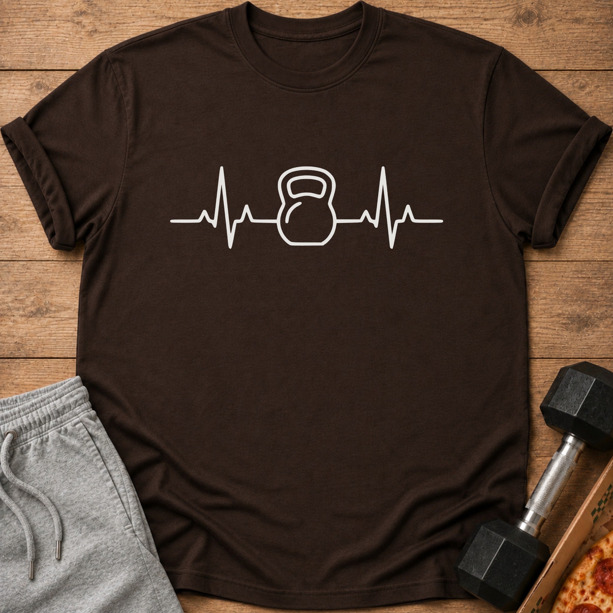 Brown t-shirt with white kettlebell heartbeat graphic and grey sweatpants.