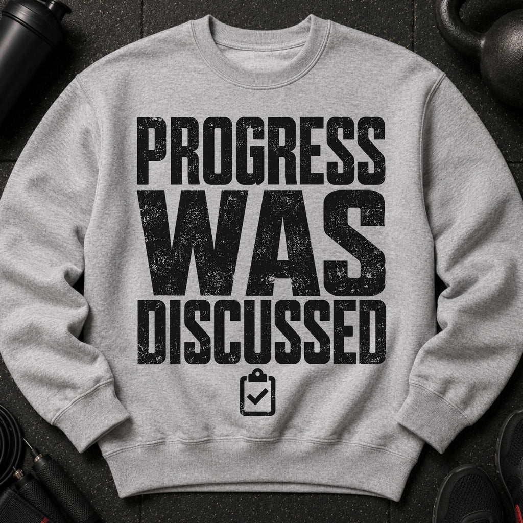 Grey sweatshirt with black distressed text "PROGRESS WAS DISCUSSED" and a checklist icon.