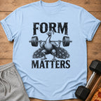 Light blue t-shirt with black text and a peacock lifting a barbell.