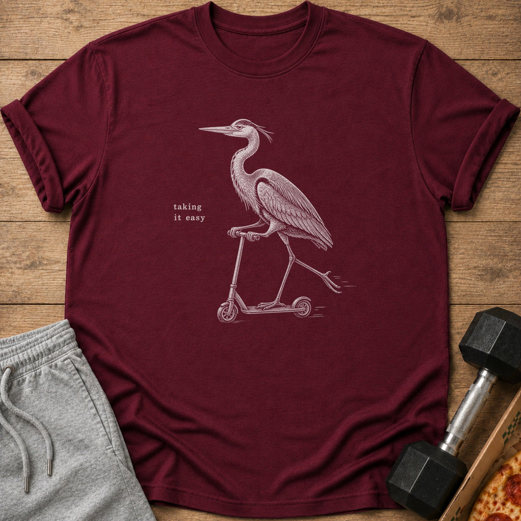 Maroon t-shirt with a white graphic of a heron riding a scooter and text saying "taking it easy".