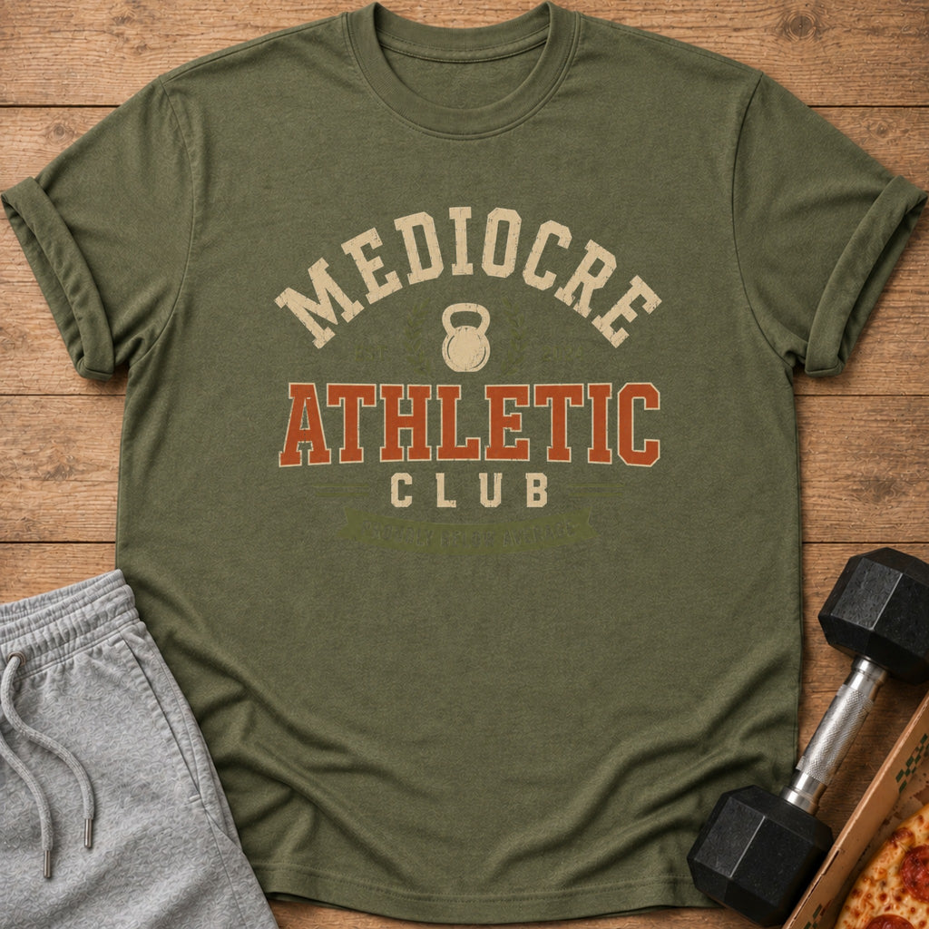 Olive green t-shirt with "Mediocre Athletic Club" text and kettlebell graphic.