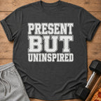 Dark gray t-shirt with "PRESENT BUT UNINSPIRED" text in white block letters.