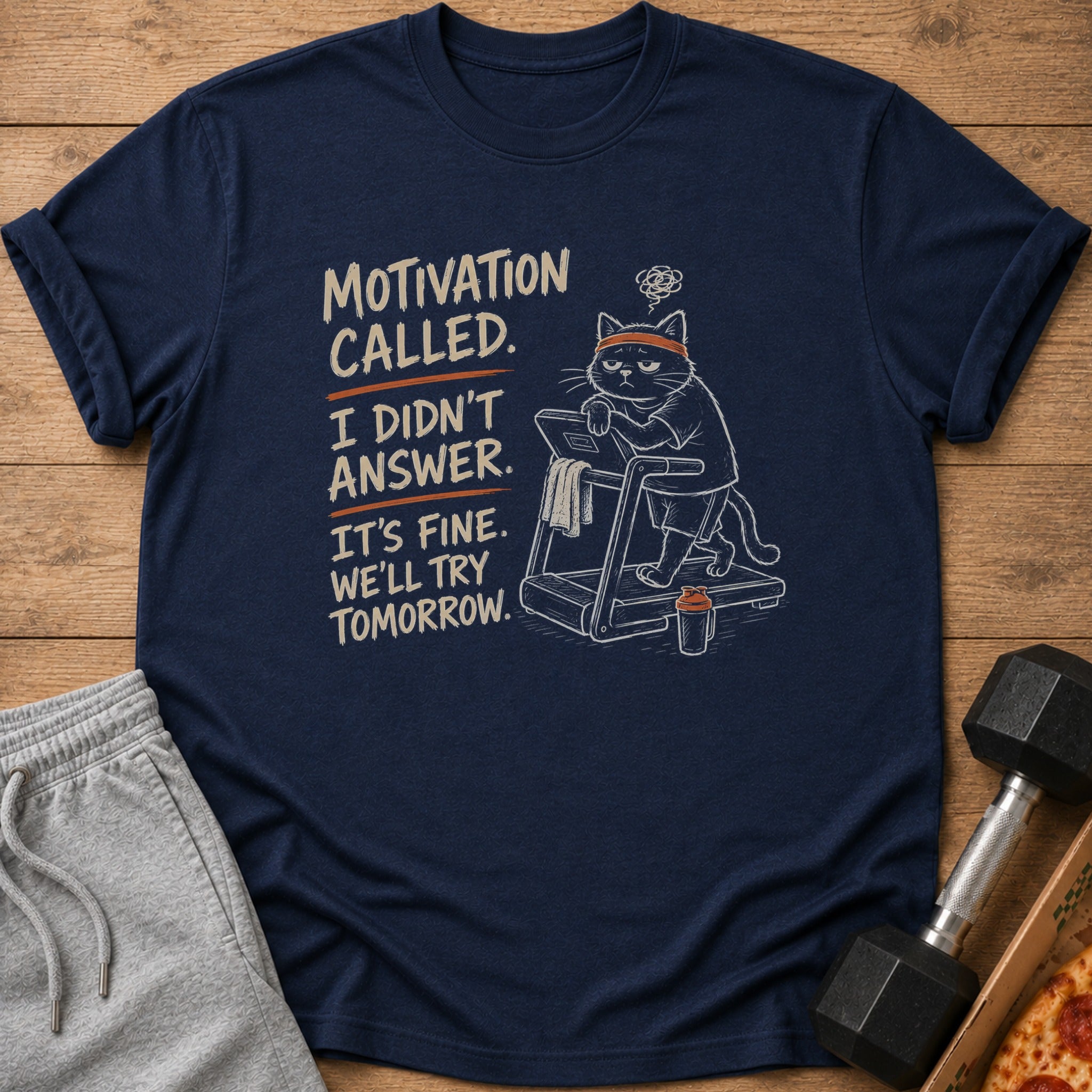 Navy t-shirt with a graphic of a cat on a treadmill and text "Motivation called. I didn't answer."