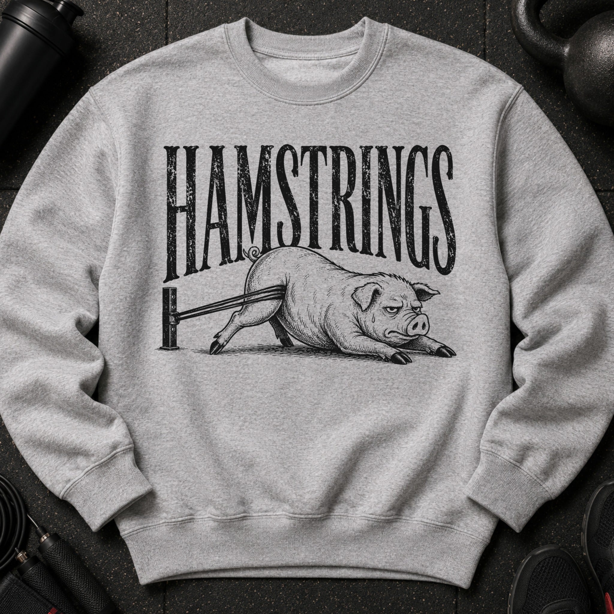 Gray sweatshirt with black text "HAMSTRINGS" and a pig doing leg curls.