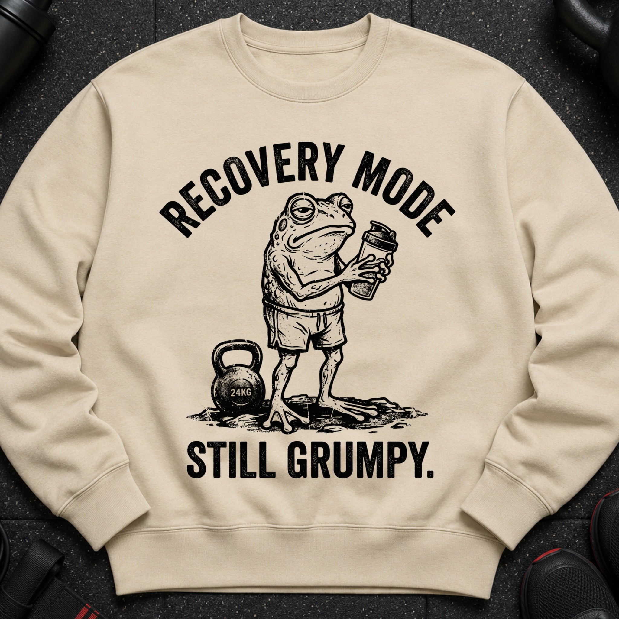 Cream sweatshirt with a grumpy frog holding a shaker, "RECOVERY MODE" above and "STILL GRUMPY." below.