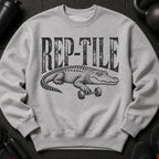 Grey sweatshirt with black "REP-TILE" text and alligator lifting dumbbell graphic.