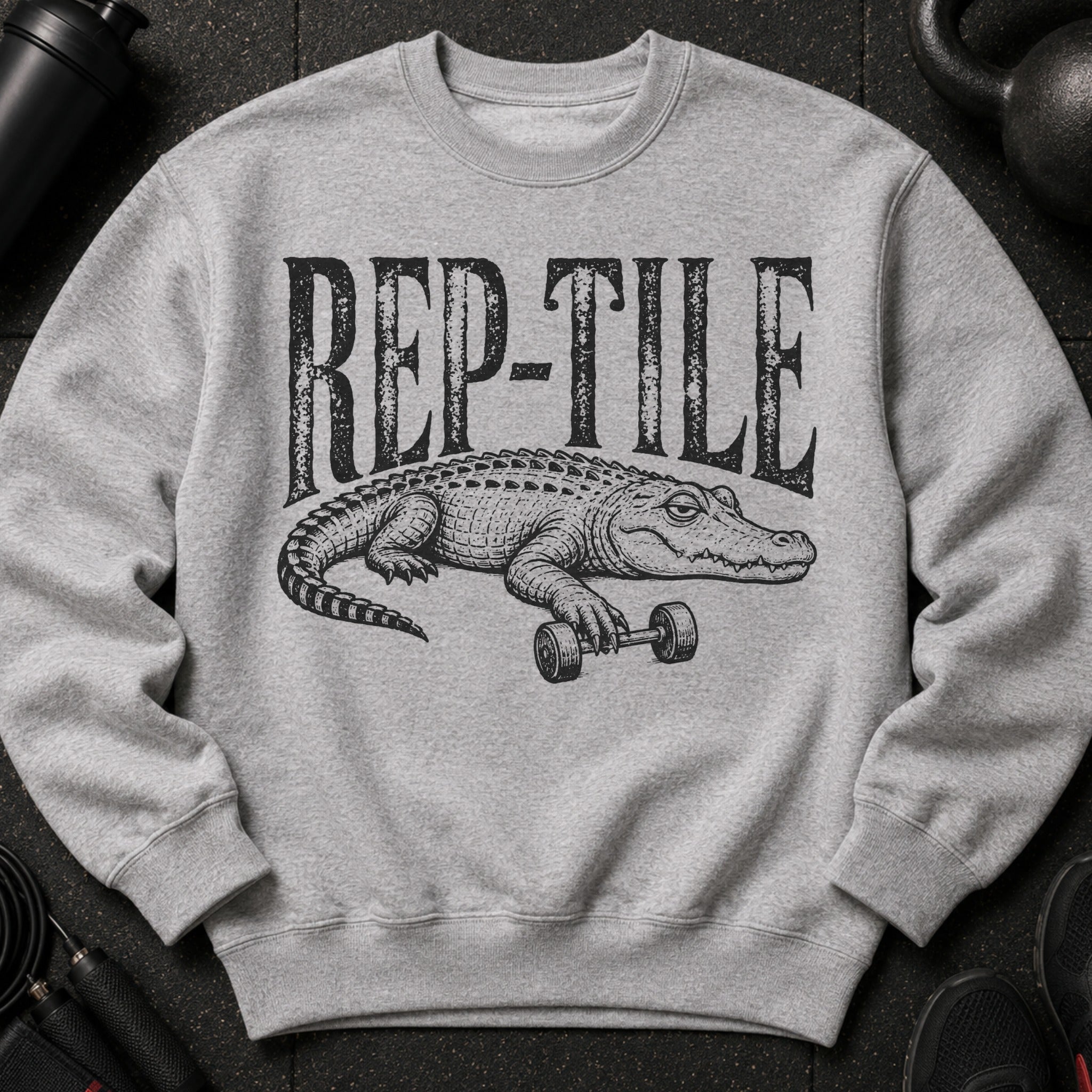 Grey sweatshirt with black "REP-TILE" text and alligator lifting dumbbell graphic.