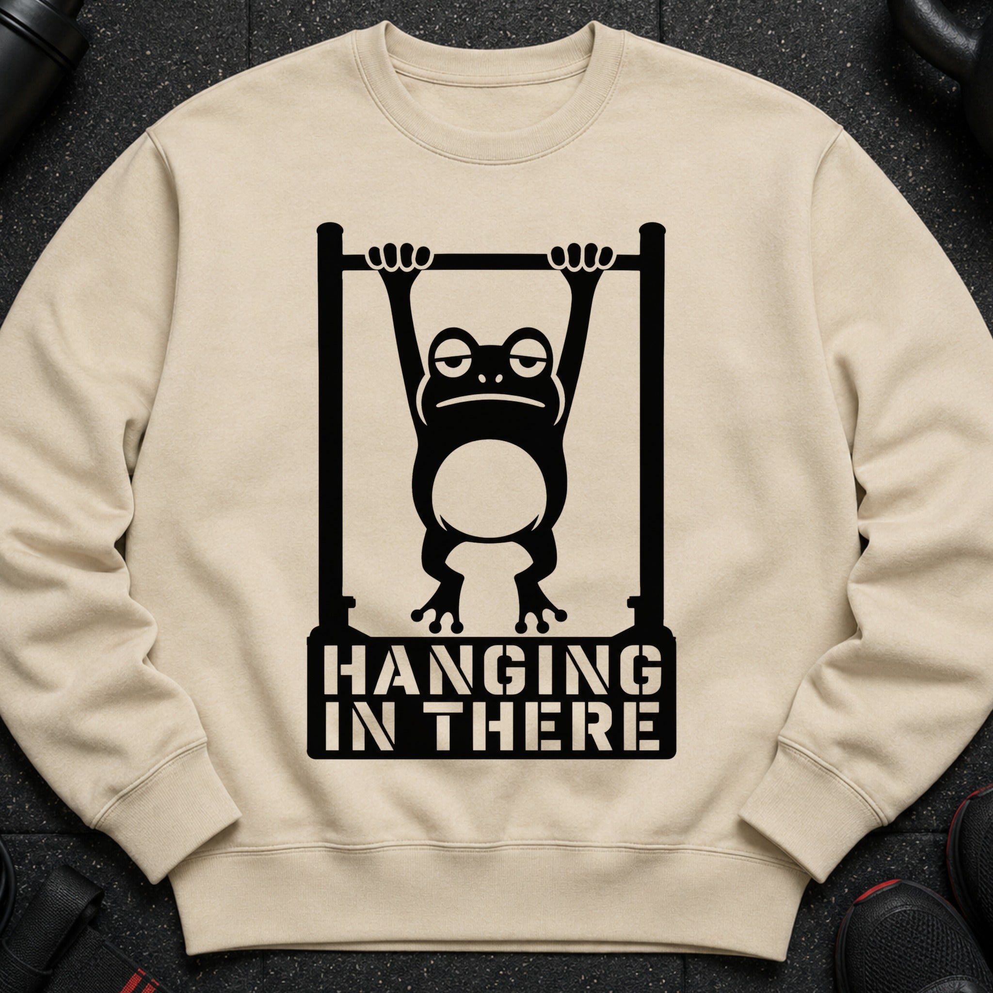 Tired frog hanging from a bar with "HANGING IN THERE" text.