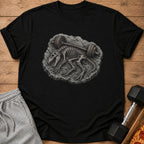 Black t-shirt featuring a dinosaur skeleton lifting a barbell on a rock.