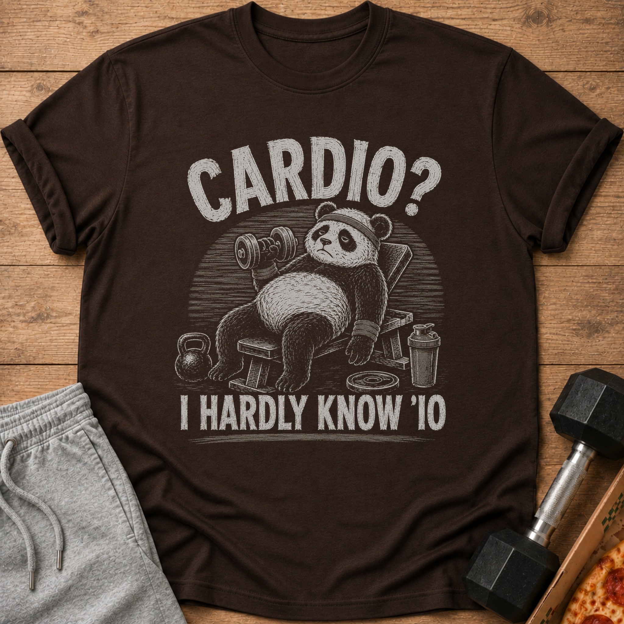 Brown t-shirt with distressed graphic of a panda on a weight bench saying "Cardio? I Hardly Know '10".