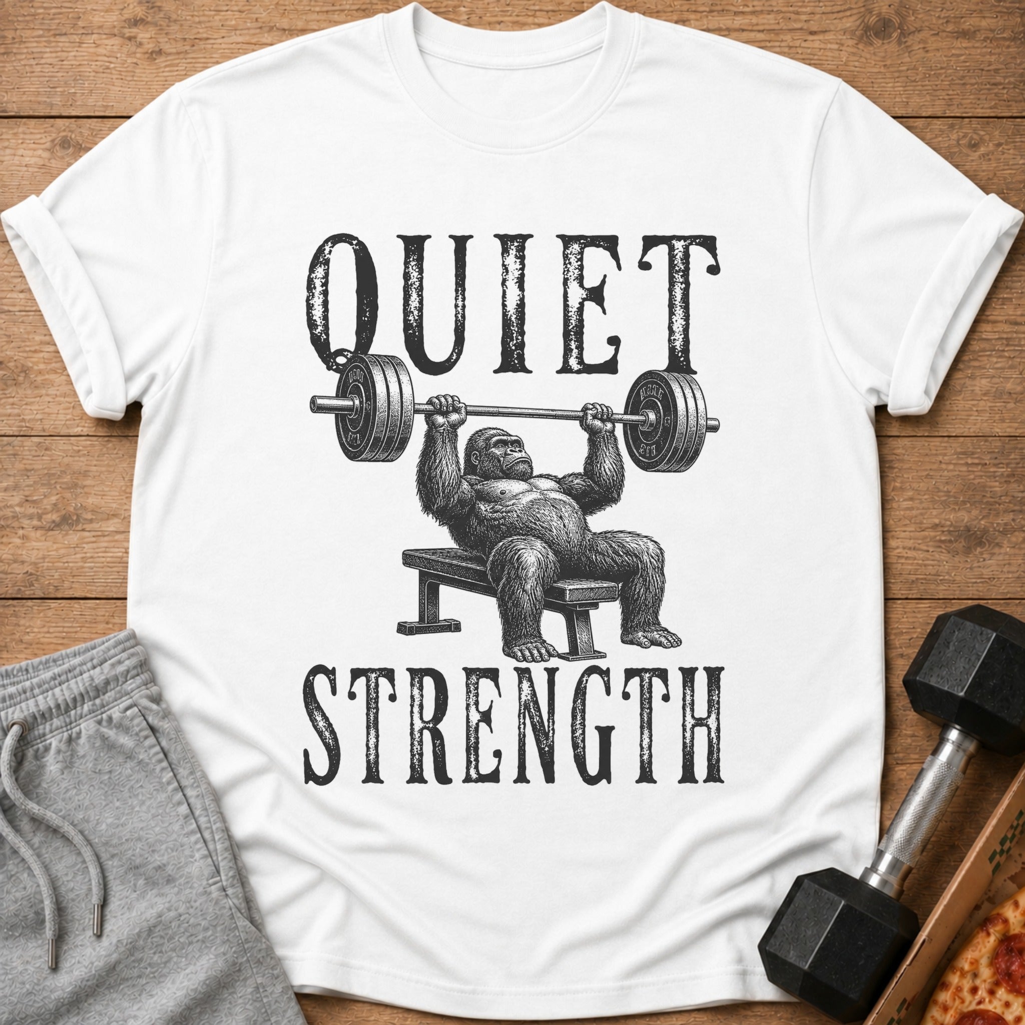 White t-shirt with gorilla bench pressing and text "QUIET STRENGTH"