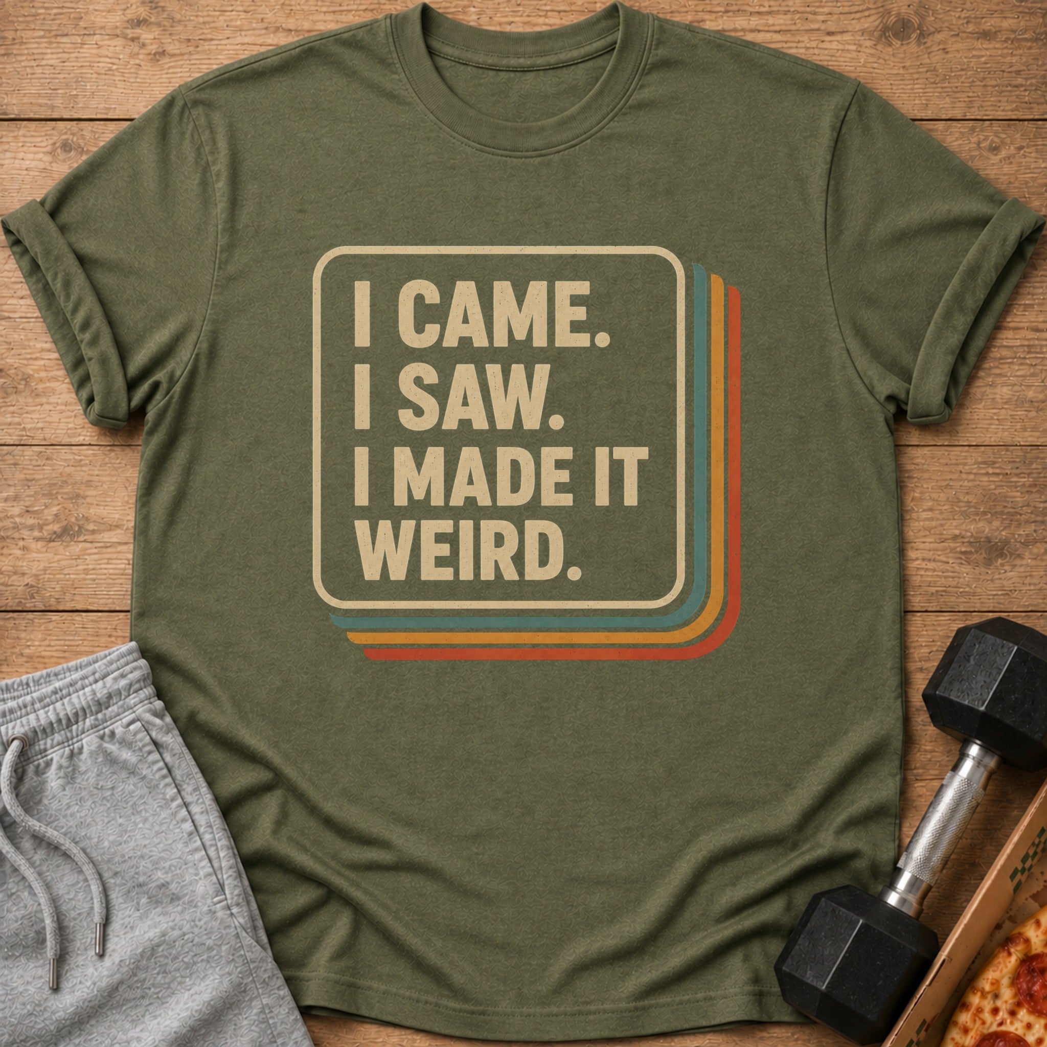 Olive green t-shirt with "I Came. I Saw. I Made It Weird." text and retro stripes.
