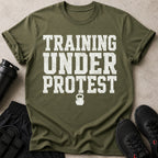 Olive green t-shirt with distressed white text "TRAINING UNDER PROTEST" and kettlebell graphic.