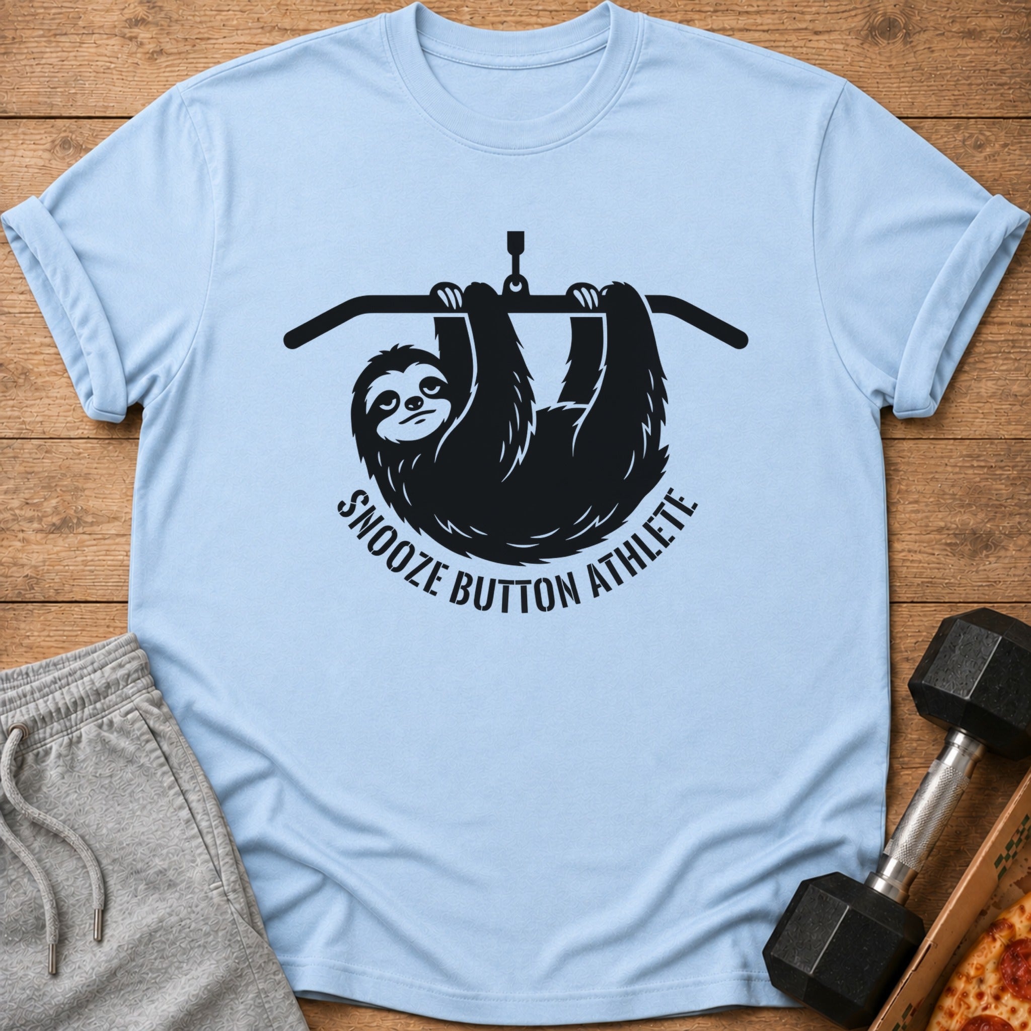 Light blue t-shirt with a black sloth hanging from a bar and text "Snooze Button Athlete".