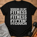 Black t-shirt with "Working on my fitness and by fitness I mean fittin' back on the couch" text.