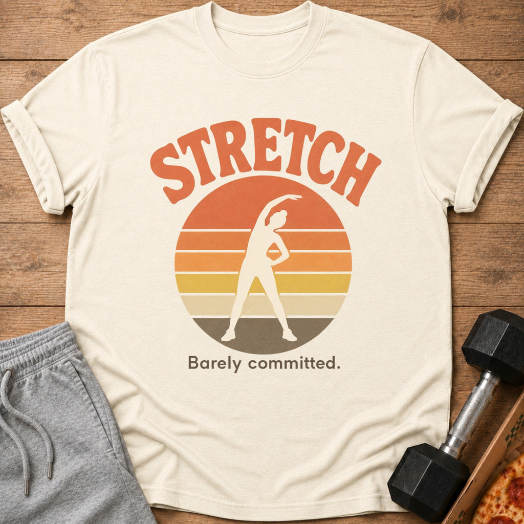 Cream t-shirt with "STRETCH Barely committed" and a figure stretching at sunset.