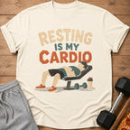 T-shirt with "RESTING IS MY CARDIO" text and illustration of a man resting on a weight bench.