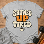 Grey t-shirt with "SHOWED UP TIRED" text and coffee cup graphic.