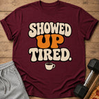 Maroon t-shirt with "SHOWED UP TIRED." text and coffee cup graphic.
