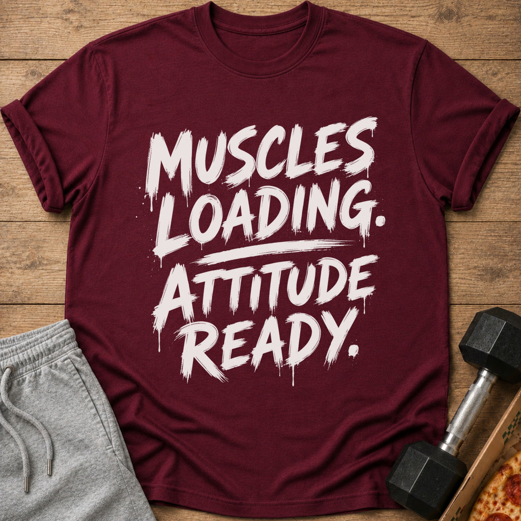 Maroon t-shirt with "Muscles Loading. Attitude Ready." text, grey shorts, and dumbbell.