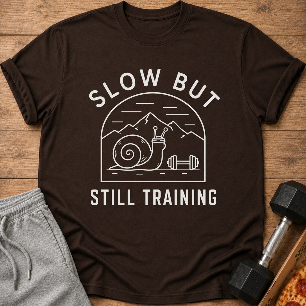 Brown t-shirt with "SLOW BUT STILL TRAINING" text and a snail lifting weights.