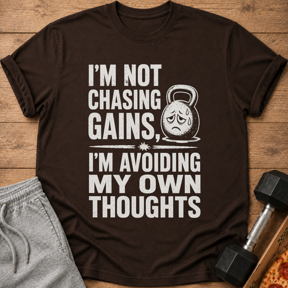Brown t-shirt with text "I'm Not Chasing Gains, I'm Avoiding My Own Thoughts".