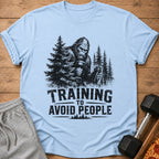 Bigfoot with weights and shaker bottle, text "TRAINING TO AVOID PEOPLE".