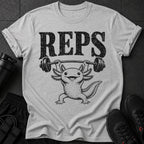 Grey t-shirt with black distressed text "REPS" and an axolotl lifting a barbell.