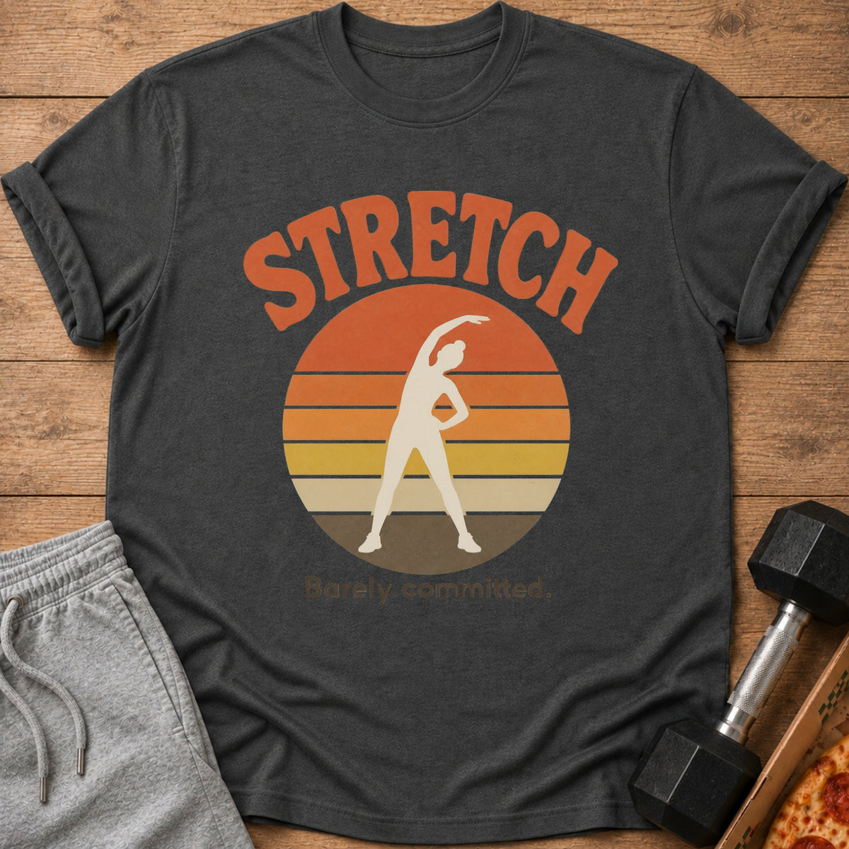 Dark t-shirt with "STRETCH Barely committed." text and stretching silhouette.