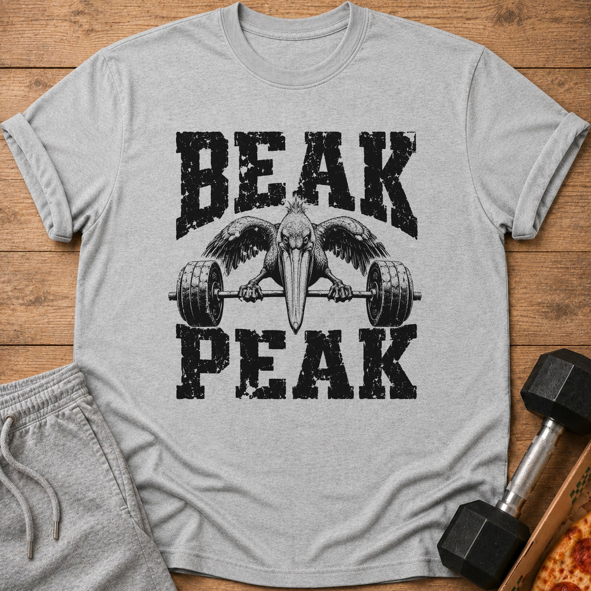 Grey t-shirt with black distressed text "BEAK PEAK" and a pelican lifting a barbell.