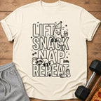 Shirt with "Lift Snack Nap Repeat" text and cartoon graphics of a banana, raccoon, and coffee.