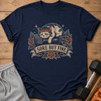 T-shirt with a sad cat wearing a headband on a dumbbell, text says "Sore But Fine."