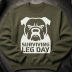 Green sweatshirt with white bulldog graphic and "Surviving Leg Day" text.
