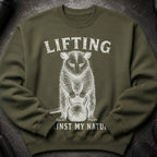 Olive sweatshirt with raccoon graphic and text "LIFTING AGAINST MY NATU".